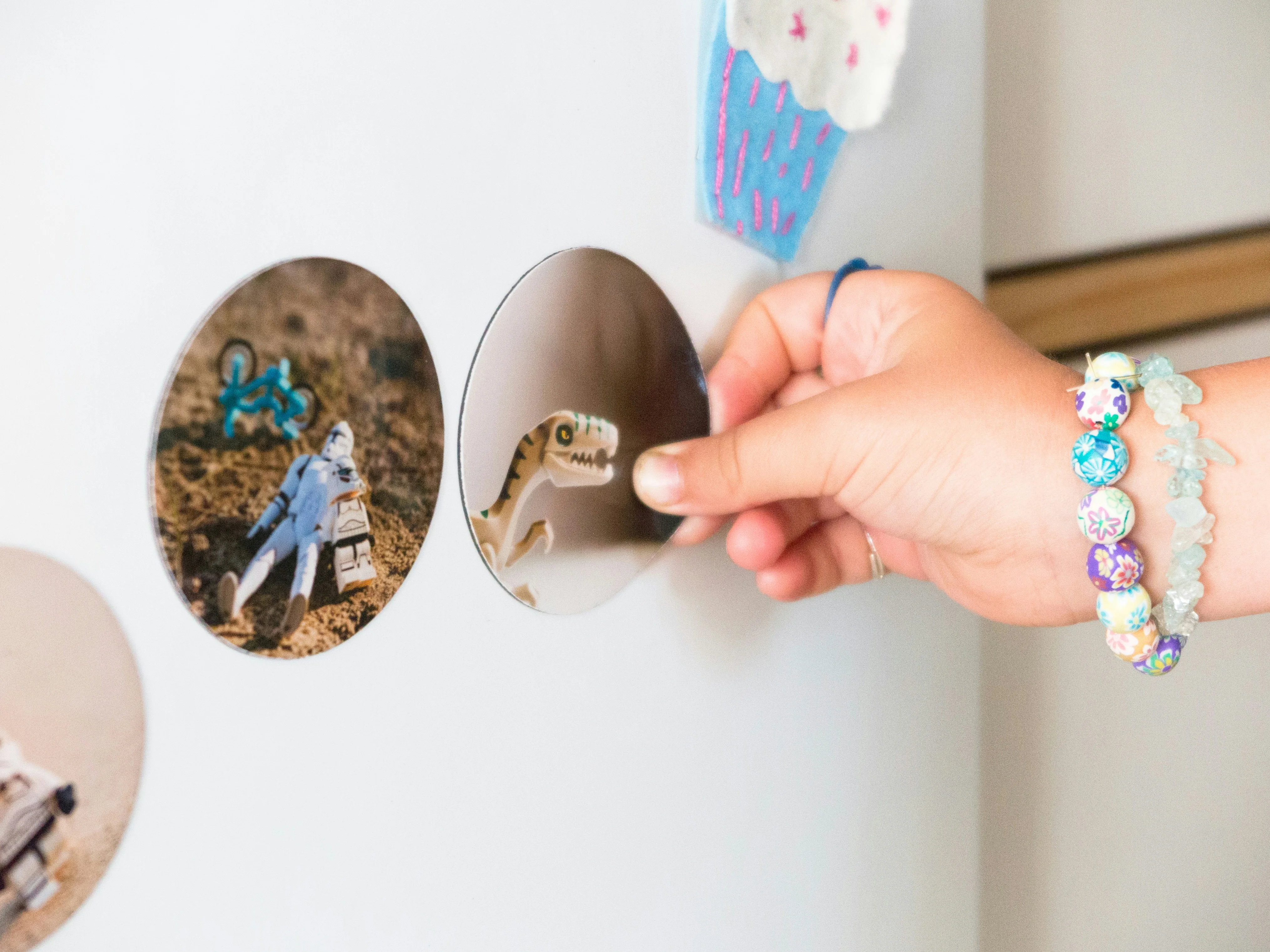 a woman’s hand is holding a magnet on a refrigerator